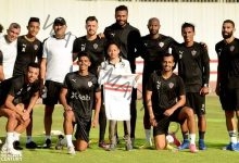 اللاعبون والجهاز الفني يلتقطون صورًا تذكارية مع مشجع الزمالك "محارب السرطان"