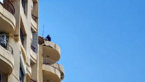 شاب يعتلي عقارًا بالإسكندرية ويثير أزمة أثناء محاولة إنقاذه.. والأهالي يتابعون المشهد بقلق